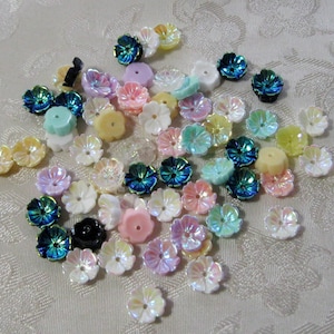 May include: Assortment of iridescent pastel and jewel-toned flower-shaped embellishments. The embellishments are made of plastic and have a shiny finish.