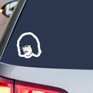 May include: A white vinyl decal featuring a stylized graphic illustration of a person with a large afro hairstyle, a mustache, and round glasses. The design is a solid silhouette with cutouts for facial features and hair texture details.