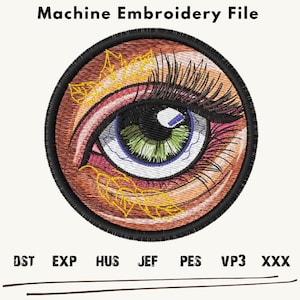 Puede incluir: Diseño de archivo de bordado a máquina de un ojo estilizado con pestañas, un iris verde y una pupila azul. El ojo está rodeado de hojas marrones y doradas.