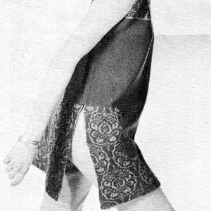 May include: A black and white photo of a woman wearing a sleeveless dress with a lace pattern. The dress has a side slit and the woman is looking over her shoulder.