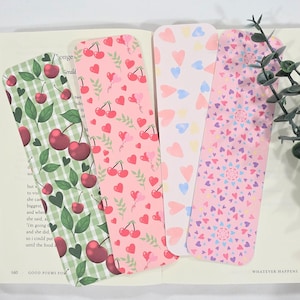 May include: Four decorative bookmarks with various patterns. One features cherries on a green checkered background, another has cherries and hearts on pink, a third has hearts, and the last has a heart mandala design.