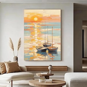 Puede incluir: Una pintura al óleo vertical sobre lienzo que representa tres veleros flotando en aguas tranquilas durante el atardecer. La escena presenta un sol naranja brillante, luz dorada reflejada en el agua y tonos suaves azules y melocotón.