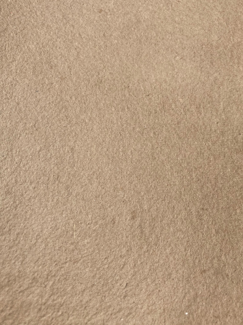 Może przedstawiać: Zbliżenie na jasnobrązową, teksturowaną powierzchnię. Powierzchnia ma subtelną, ziarnistą fakturę.