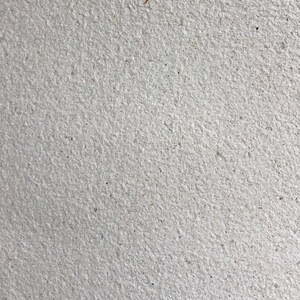 May include: A close-up of a white textured wall with a rough, grainy surface.