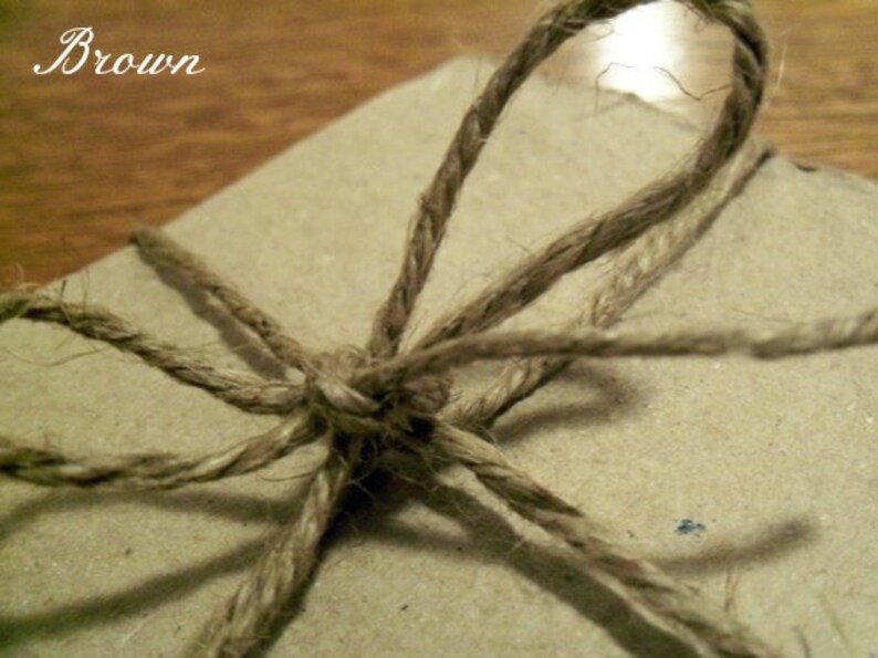 Op de afbeelding: Een bruin papieren pakketje dat vastgebonden is met touw. Het touw is bovenop het pakketje in een strik geknoopt.