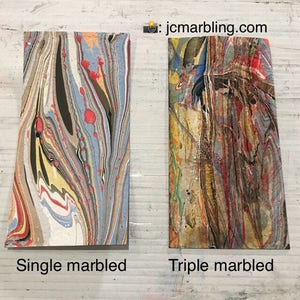 May include: Two pieces of marbled paper, one with a single marbling and the other with a triple marbling. The single marbled paper has a light blue, yellow, and red color scheme. The triple marbled paper has a darker brown, yellow, and red color scheme.