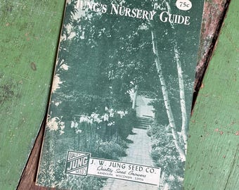 May include: A vintage Jung's Nursery Guide booklet with a dark green cover featuring a black and white photograph of a garden path. The text reads Jung's Nursery Guide, 75c, and J.W. Jung Seed Co. Quality Seed Growers, Randolph, Wisconsin 53956.