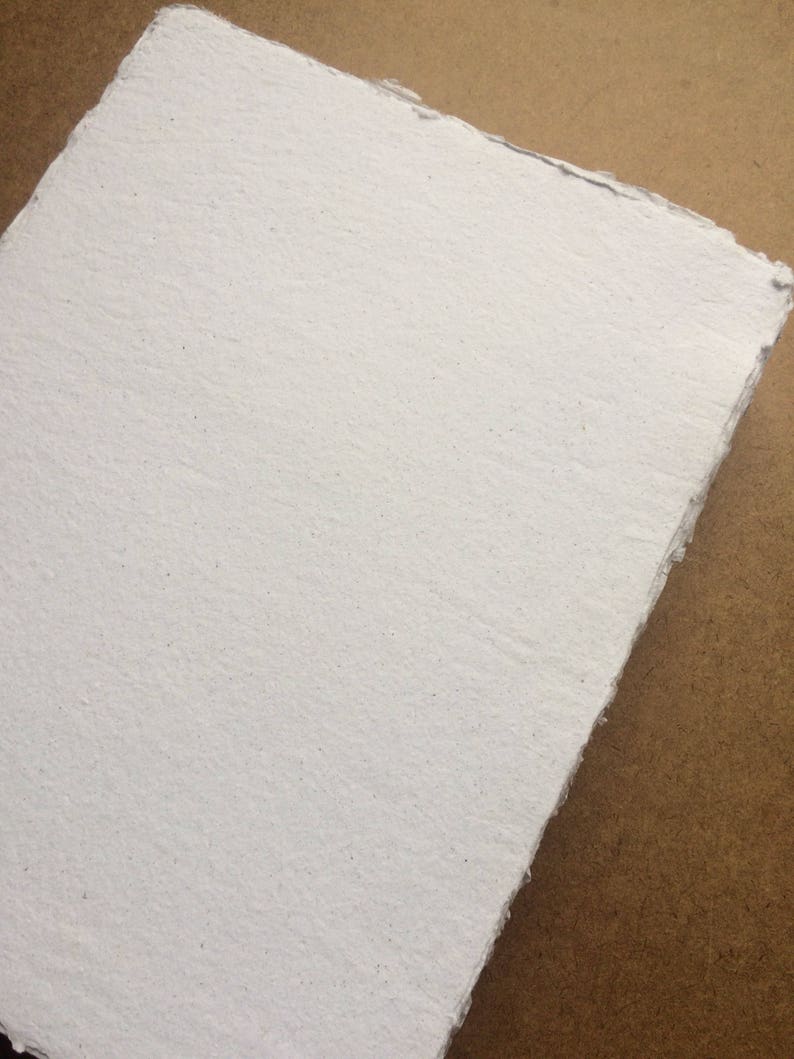 May include: A sheet of white handmade paper with a rough, textured surface.