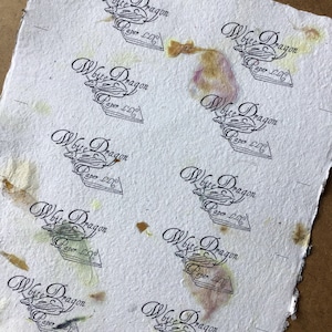 Może przedstawiać: Arkusz białego papieru z wieloma stemplami czarno-białego logo z napisem "White Dragon Paper LLC". Papier ma brązowe, ż&oacute;łte i fioletowe plamy.