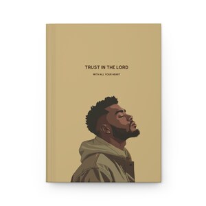 May include: A tan notebook with the text "TRUST IN THE LORD WITH ALL YOUR HEART" and a digital illustration of a man with a beard looking up.
