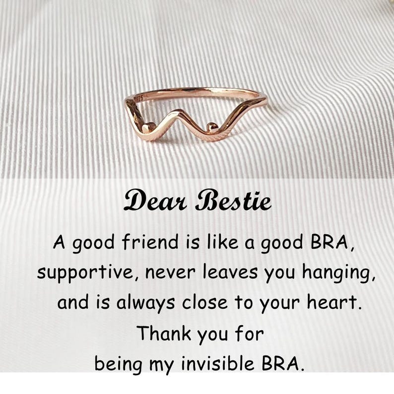 May include: A rose gold ring with a wavy design and two small spheres. The ring is on a white and gray striped background. The text "Dear Bestie" is above a quote about friendship.