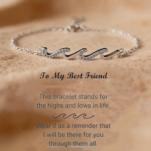 Może przedstawiać: Srebrna bransoletka z motywem fali, ozdobiona małymi, przezroczystymi kamieniami. Tekst "To My Best Friend" jest wyświetlany poniżej, wraz z przesłaniem o wzlotach i upadkach w życiu.