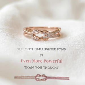 Könnte beinhalten: Roségoldener Ring mit Knoten-Design, besetzt mit kleinen, funkelnden Edelsteinen. Der Ring ist vor einem weichen, weißen Hintergrund platziert. Text: "DIE MUTTER-TOCHTER-BINDUNG IST Noch Mächtiger ALS DU DACHTEST."
