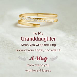 May include: A gold-colored ring with a wrap-around design, adorned with small, clear gemstones. The ring is featured with text that reads "To My Granddaughter" and "A Hug from me to you with love & kisses."