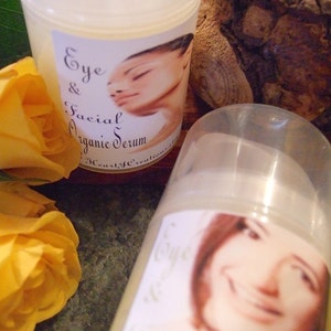 Puede incluir: Dos botellas de vidrio transparente con etiquetas blancas. Las etiquetas tienen el texto "Eye & Facial Organic Serum" y muestran el rostro de una mujer. Las botellas est&aacute;n sobre una superficie marr&oacute;n oscura.