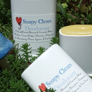 May include: Two white deodorant containers with a red heart and the text "Soapy Clean Deodorant" on the label. The label lists the ingredients: Oils of Sweet Almond & Coconut, Shea Butter, Cocoa Butter, Beeswax, Vitamin & Rosemary, Neem, Cyprus, & Tea Tree.