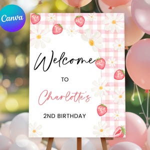 Peut inclure: Panneau de fête sur chevalet avec l'inscription « Bienvenue à Charlotte's 2nd Birthday ». Le panneau a un fond vichy rose avec des illustrations de marguerites et de fraises. Des ballons roses et blancs sont en arrière-plan.