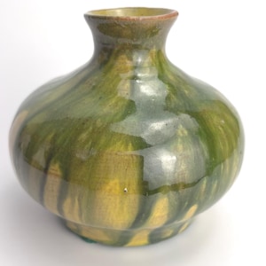 Könnte beinhalten: Eine kleine, bauchige Keramikvase mit glänzender Oberfläche. Die Oberfläche zeigt ein marmoriertes, ineinander verlaufendes Muster in dunklem Waldgrün, Oliv und Senfgelb. Sie hat einen schmalen, ausgestellten Hals und einen zum Boden hin verjüngten Körper.