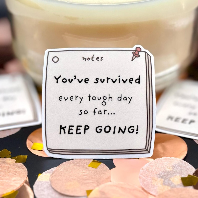 May include: A square sticker designed to look like a notepad page with a pink pushpin icon in the corner. The text reads: notes, You've survived every tough day so far... KEEP GOING! The sticker has a white border and a light beige background.