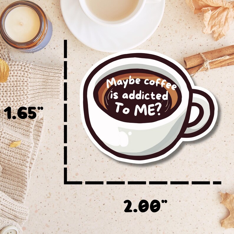 May include: A die-cut sticker shaped like a coffee cup with dark brown liquid inside. The text reads, "Maybe coffee is addicted To ME?". The sticker measures 1.65 inches in height and 2.00 inches in width as indicated by the visible measurement markings.