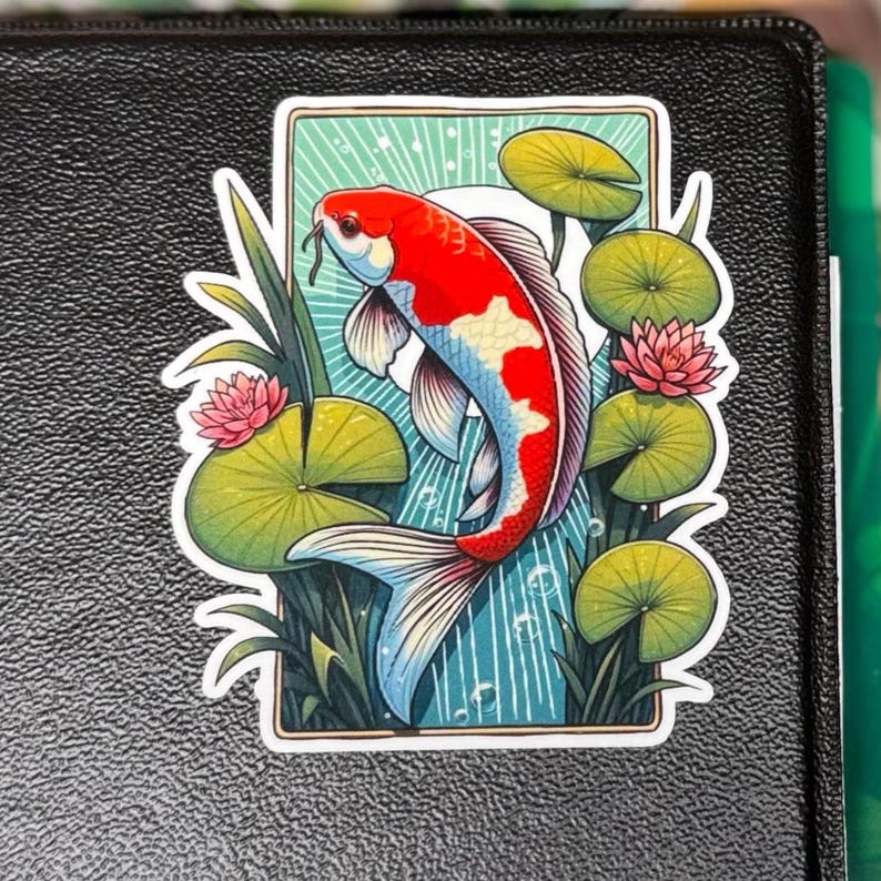 a rectangle shaped sticker of a koi fish swimming in a lilly pond, white sun and rays in background. the lillys stick out beyond the rectangle creating a 3D effect. the sticker is placed to the top right of a black 3-ring binder.