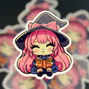 a sticker of a young witch pink hair. happy and smiling eyes closed, big black eyelashes. purple/black witch hat with pink bow. holding a book that says Book of Spells Junior Witch. duplicates in blurred background.