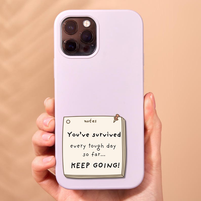 May include: A light purple smartphone case featuring a graphic of a cream-colored sticky note. The note has the text "notes" at the top and the message "You've survived every tough day so far... KEEP GOING!" printed in black ink.