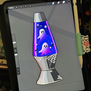 May include: A digital illustration of a lava lamp on a tablet screen. The lamp features a blue liquid interior with two purple ghosts, small black bats, and white bubbles. The base is silver and black, decorated with white spider web line art.