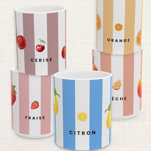 May include: White ceramic mugs with vertical striped patterns in various colors, each featuring a different fruit illustration and name. Fruits include cherries, strawberries, oranges, peaches, and lemons. The mugs are stacked.