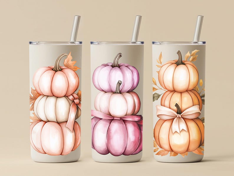 May include: Three stainless steel tumblers with stacked pumpkin designs. Each tumbler features a different colour scheme: peach, pink, and orange. The pumpkins are adorned with leaves and bows, and each tumbler has a silver straw.