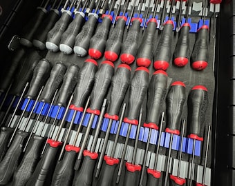 May include: A drawer full of black and red screwdrivers with blue and gray organizers. The screwdrivers are arranged in rows and are all the same size.