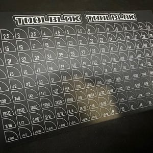May include: Black TOOLBLOK card with white lettering and numbers. The card is filled with various sizes and measurements, including numbers, fractions, and specialized tool designations. The TOOLBLOK logo is at the top.