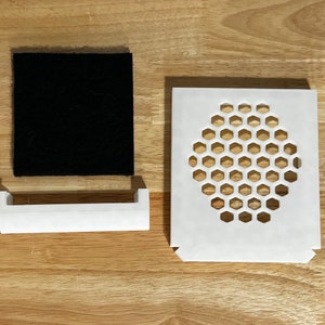 May include: A white plastic air filter with a honeycomb-shaped grill, a white plastic frame, and a black foam filter.