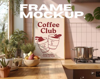 May include: A framed poster with the text "Coffee Club" and two coffee cup illustrations. The poster is in a kitchen setting with plants, a bowl of fruit, and a stainless steel pot on a stove.