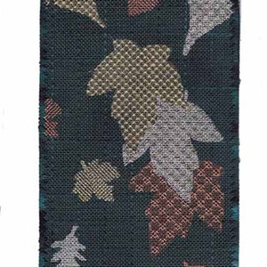 May include: A green tapestry with a pattern of colorful leaves. The tapestry is woven with a textured fabric and has a fringe border.