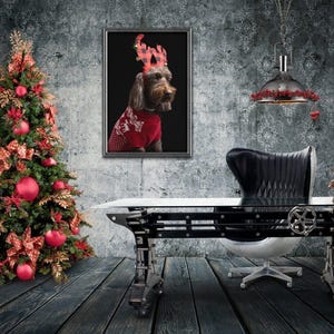 May include: A black leather office chair with a silver base sits in front of a large industrial-style desk with a glass top. A Christmas tree with red ornaments is in the background, and a framed photo of a dog wearing a red and black reindeer antler headband is on the wall.