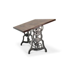 May include: A rectangular wooden table with a dark brown surface. The table is supported by a cast iron base with intricate, industrial-style detailing. The base is a dark gray color. The table is angled slightly, showcasing its design.