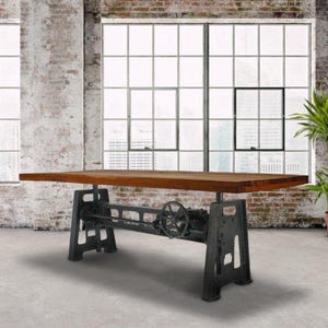 May include: A rectangular wooden table with a dark brown finish and a thick top. The base is constructed from black metal, featuring a central hand crank mechanism and two sturdy, industrial-style legs that support the heavy tabletop structure.