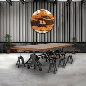 May include: A large wooden dining table with a rectangular top and a metal base with wheels. Several small wooden stools with metal legs surround the table. A large round wooden clock hangs on the wall above the table. The clock has a unique wood grain design.