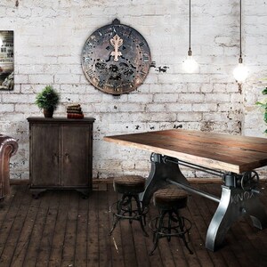May include: A rustic industrial-style dining room with a large wooden table supported by metal legs. The room features a leather sofa, a wooden cabinet, and a decorative clock on a brick wall. Two stools are placed near the table.
