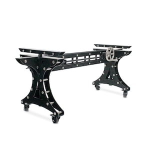 May include: Black metal table base with adjustable height, featuring a wheel on each leg and a hand crank for height adjustment. The base is designed for a rectangular table top.