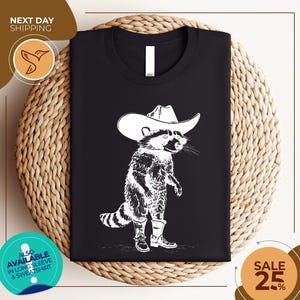 a black shirt with a raccoon wearing a cowboy hat