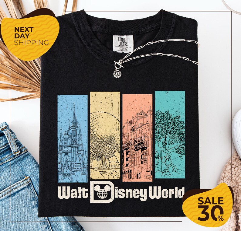 a black t-shirt with a graphic design depicting various landmarks and attractions from Walt Disney World, including the Eiffel Tower, the Disney castle, and the Wood Tower. The t-shirt is displayed on a white background, and there are two yellow sale signs indicating a 30% discount on the item.
