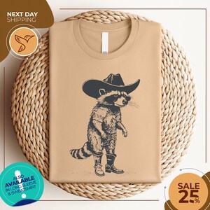 a t - shirt with a raccoon wearing a cowboy hat