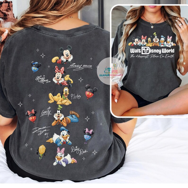 May include: Dark grey t-shirt featuring Disney characters Mickey Mouse, Minnie Mouse, Pluto, Goofy, Donald Duck, and Daisy Duck. The shirt includes the text "Walt Disney World The Happiest Place On Earth."