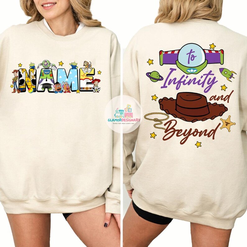 May include: A cream colored sweatshirt with a Toy Story theme. The front features the word "NAME" with characters from the movie. The back features the text "To Infinity and Beyond" with a cowboy hat and spaceship.