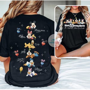 May include: Black t-shirt featuring Disney characters Mickey Mouse, Minnie Mouse, Pluto, Goofy, Donald Duck, and Daisy Duck. The back of the shirt has character illustrations and signatures. The front of the shirt has the text "Walt Disney World The Happiest Place On Earth".