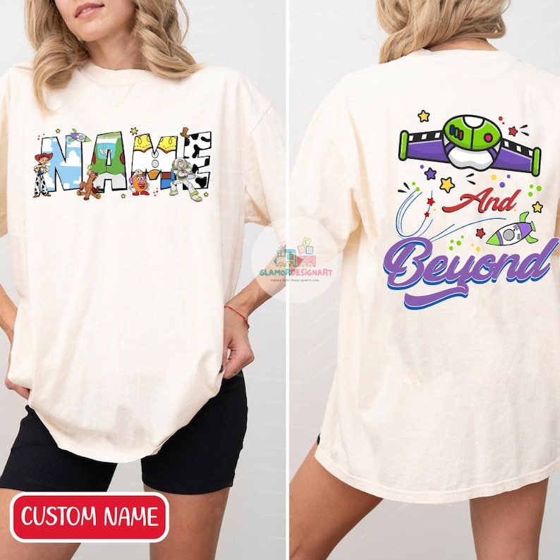 Puede incluir: Una camiseta blanca con un nombre personalizado y personajes de Toy Story en la parte delantera. La parte posterior de la camiseta tiene un gr&aacute;fico de Buzz Lightyear y el texto "And Beyond".