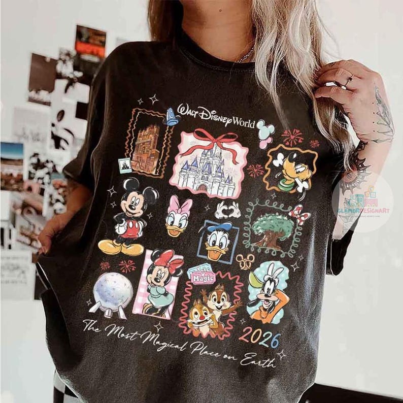 May include: Dark gray t-shirt featuring a collage of Disney characters and landmarks. The design includes Mickey Mouse, Minnie Mouse, Donald Duck, and a castle, with the text "Walt Disney World" and "2026". The shirt also has the phrase "The Most Magical Place on Earth".
