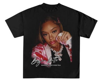 Peut inclure: T-shirt noir avec une photo d'une femme portant une veste rose et camouflage. Le texte "Big Latto" est écrit en cursive blanche avec les mots "SugarHoney Iced Tea" en dessous.